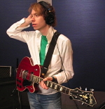 Jay Ferguson in headphones and guitar