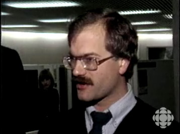Old video still frame of Jack Layton with full head of dark-brown hair and full brown moustache