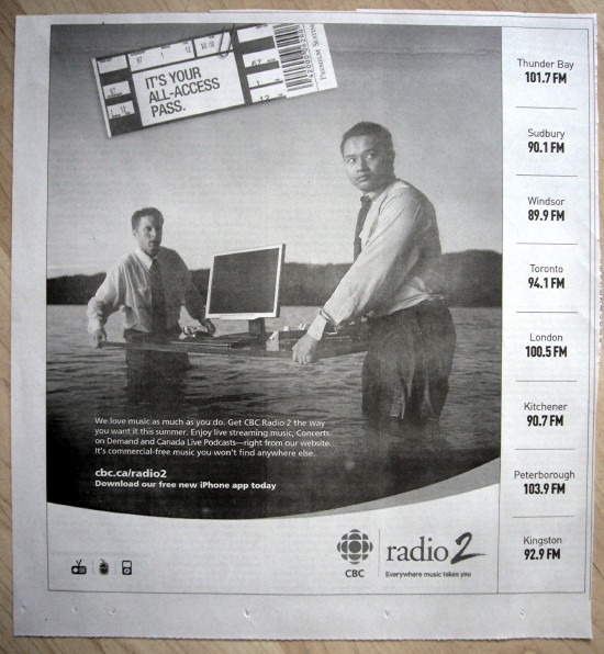 Oriental dude and white dude carry a table with a computer monitor across a lake